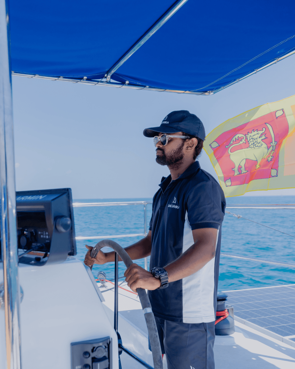 A Sail Lanka skipper at the helm of a catamaran